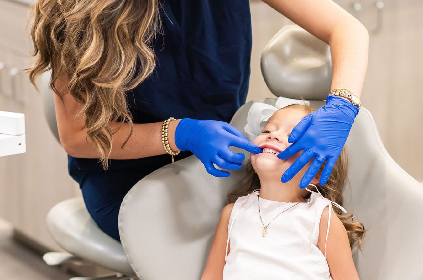 Dental hygienist cleaning a young patient’s teeth at Thomas & Moore Pediatric Dentistry