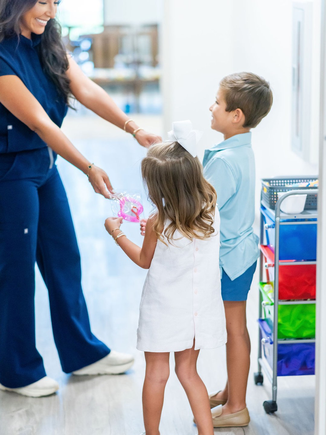Team member handing a prize to two young patients