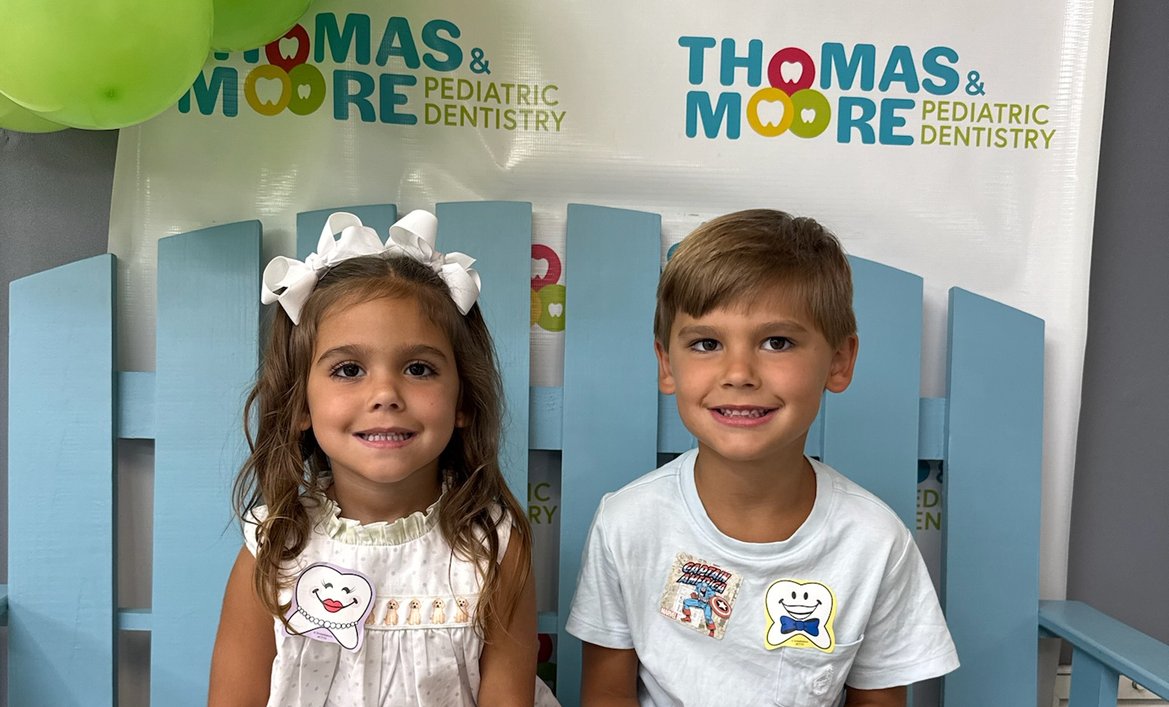 Two young patients sitting on the office bench at Thomas & Moore Pediatric Dentistry
