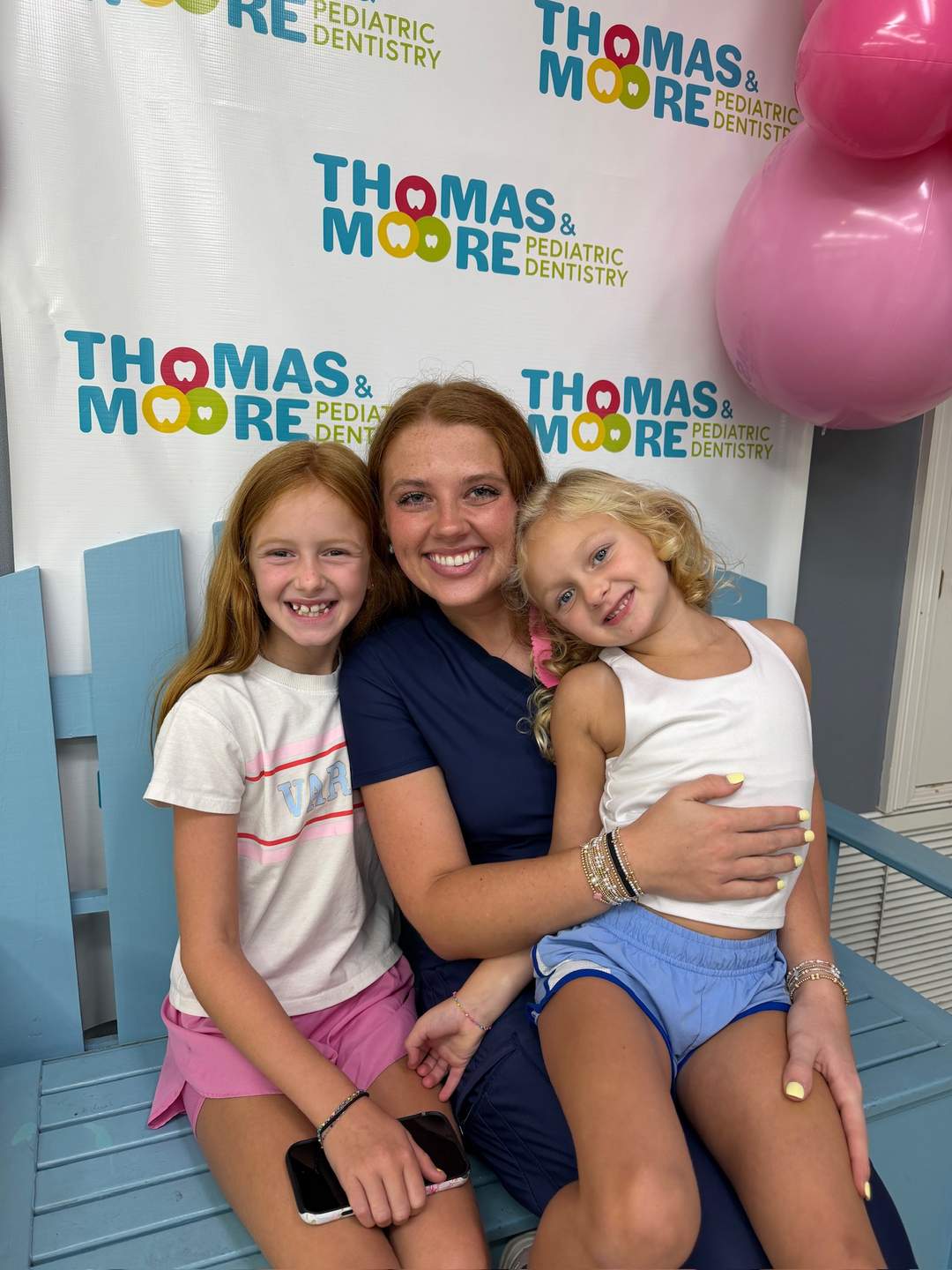Team member with two young patients at Thomas & Moore Pediatric Dentistry